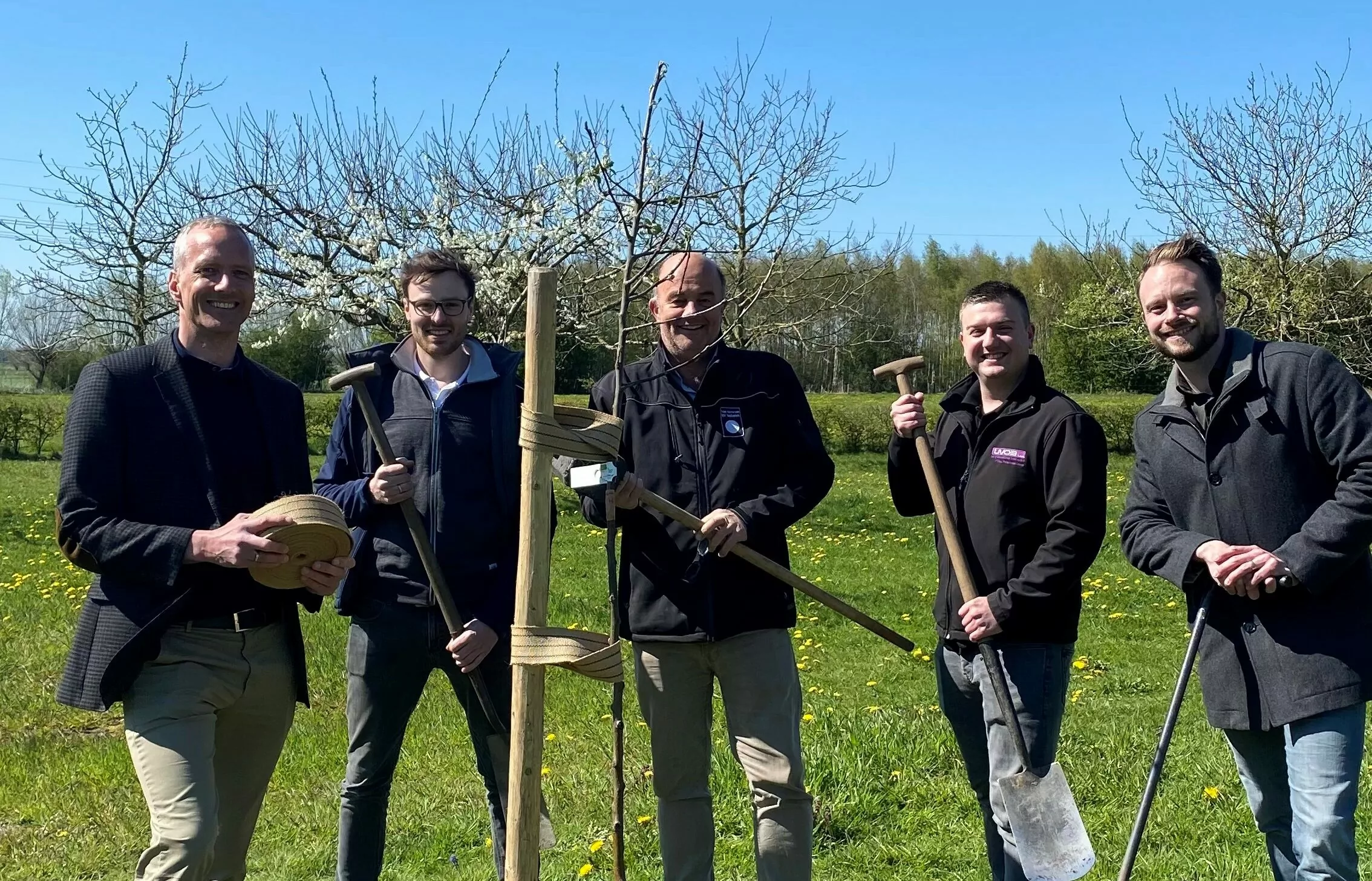 Van Remmen boom planten Van Remmen groepsfoto met klanten van het planten van een boom